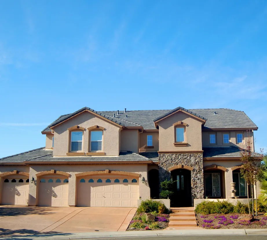 Custom home building project in Los Angeles featuring luxury two-story residential home with stucco exterior, stone entry, and landscaped driveway